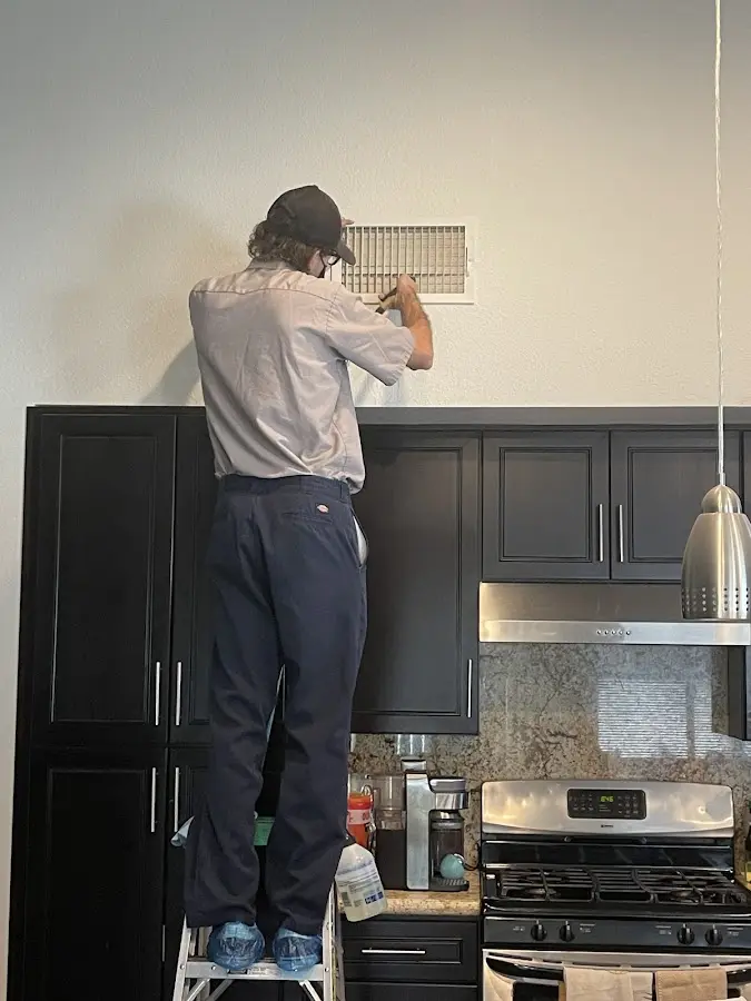 Technician inspecting an air vent during HVAC service in Burkburnett